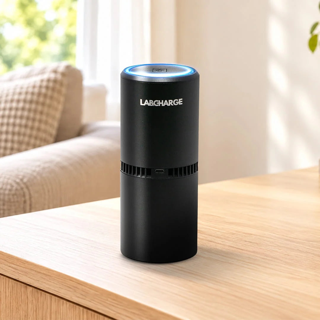 1 black Labcharge air purifier on a light oak table in a neutral living room